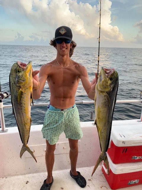 An angler holding two Mahi-Mahi caught fishing in Destin Florida